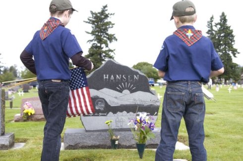 Webelos scouts Austin Harvey, left, and Jack Kolosvary, both 10, decorate veterans’ graves Saturday at Mother Joseph Catholic Cemetery.